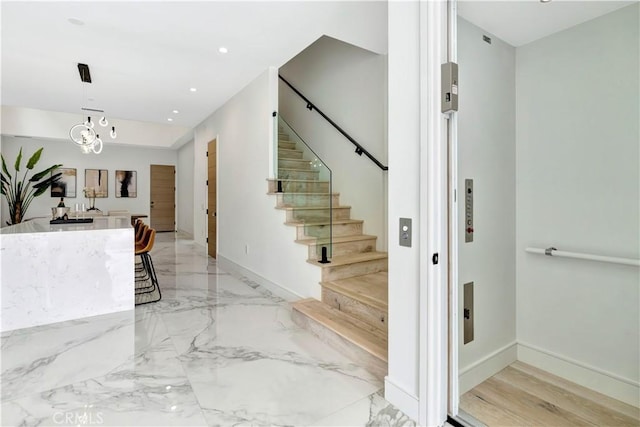 stairway featuring an inviting chandelier