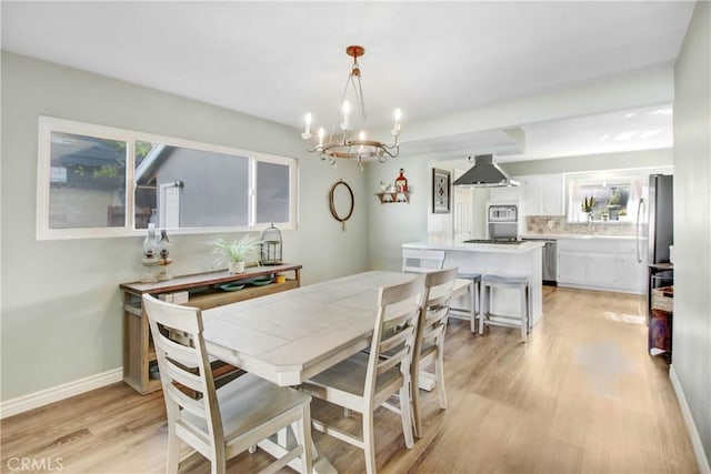 22616 Cardinal St, Grand Terrace, CA 92313 - dining area featuring a chandelier, light wood-type flooring, plenty of natural light, and baseboards
