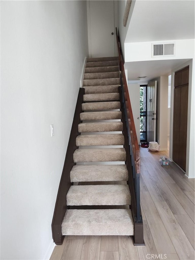 staircase with hardwood / wood-style flooring