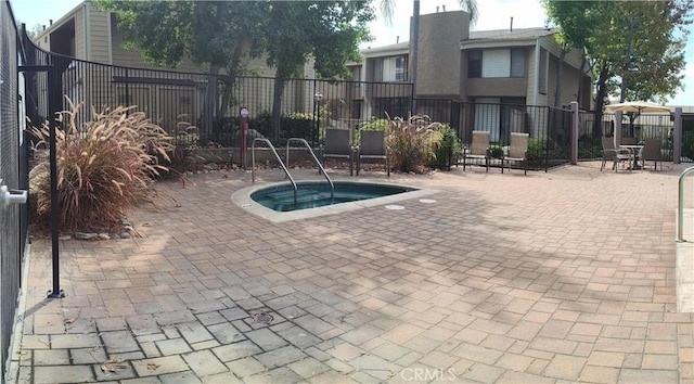 view of swimming pool with a patio area and a hot tub