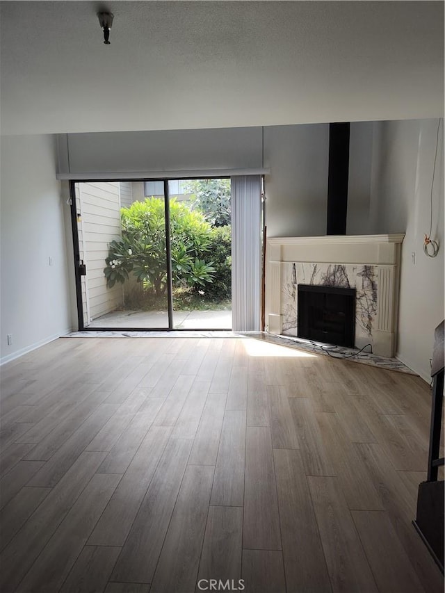 unfurnished living room featuring hardwood / wood-style flooring and a premium fireplace