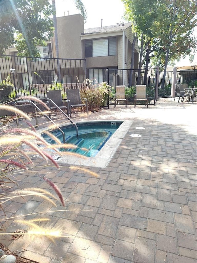 view of swimming pool with a community hot tub and a patio