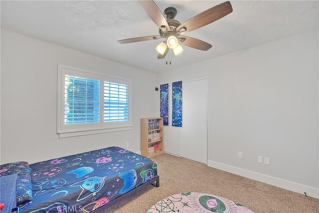 bedroom with a textured ceiling, ceiling fan, and carpet