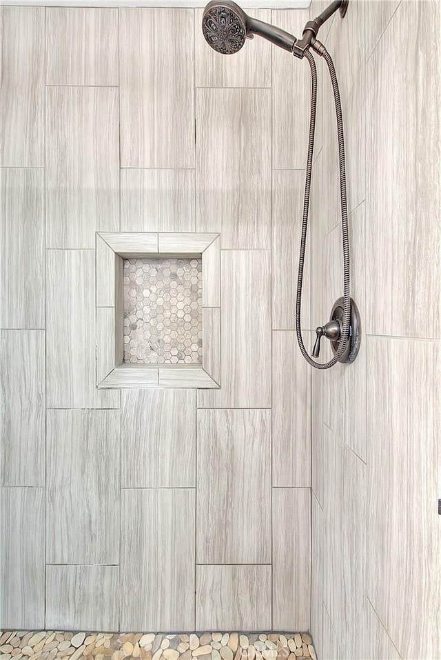 interior details with a tile shower