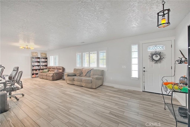 entrance foyer with a textured ceiling and light hardwood / wood-style floors