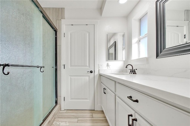 bathroom featuring walk in shower and vanity