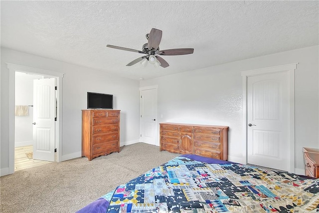 carpeted bedroom with ceiling fan, connected bathroom, and a textured ceiling