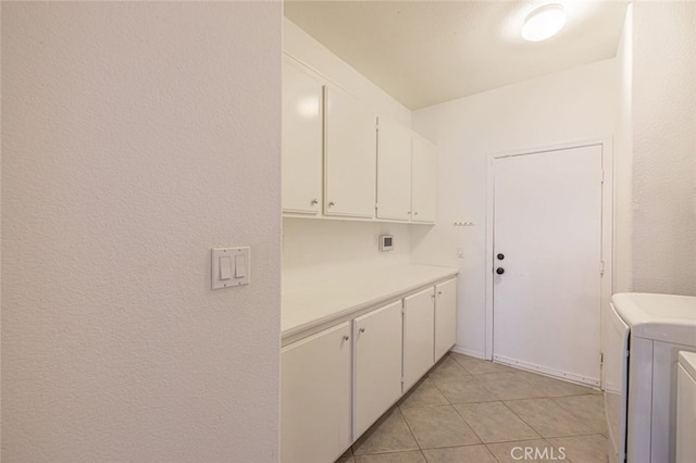 washroom featuring cabinets, light tile patterned floors, and independent washer and dryer