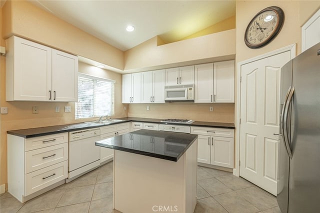 kitchen featuring lofted ceiling, a center island, light tile patterned flooring, white cabinetry, and stainless steel appliances