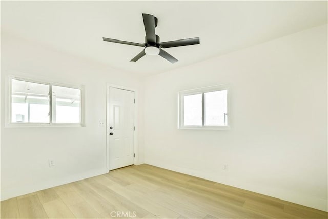 unfurnished room featuring ceiling fan, a wealth of natural light, and light hardwood / wood-style floors