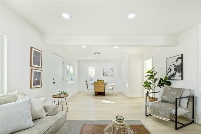 living room with beam ceiling and light hardwood / wood-style flooring