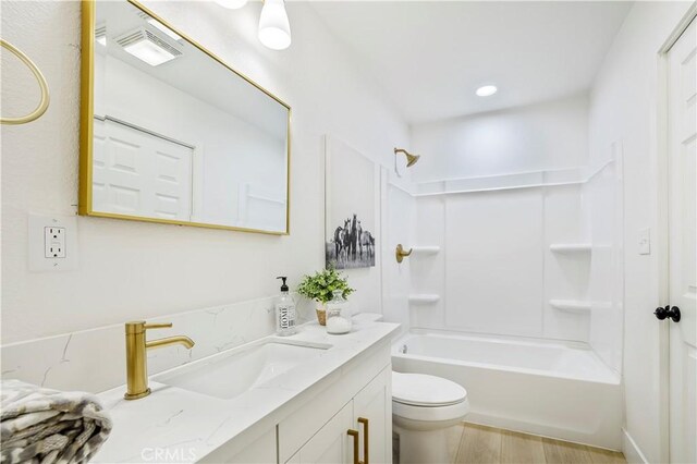 full bathroom featuring toilet,  shower combination, hardwood / wood-style floors, and vanity