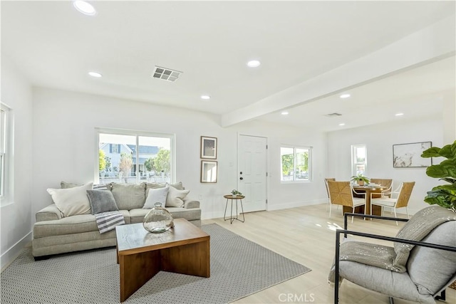 living room featuring beam ceiling and light hardwood / wood-style flooring