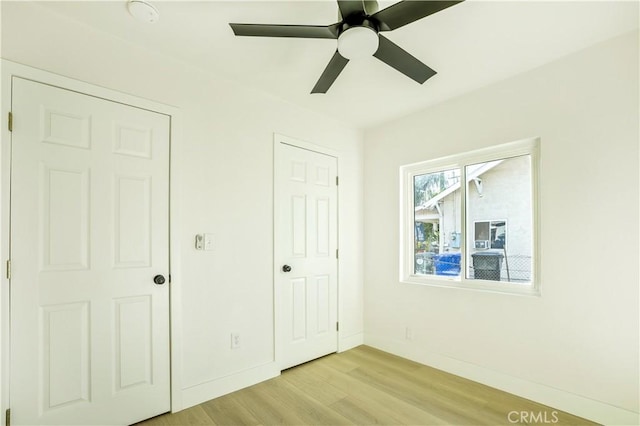 unfurnished bedroom with ceiling fan and light hardwood / wood-style floors