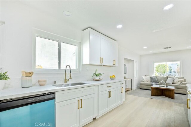 kitchen with light hardwood / wood-style floors, sink, white cabinets, and dishwasher