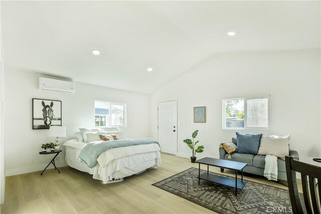 bedroom with lofted ceiling, light hardwood / wood-style flooring, and an AC wall unit