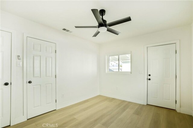 unfurnished room with light wood-type flooring and ceiling fan