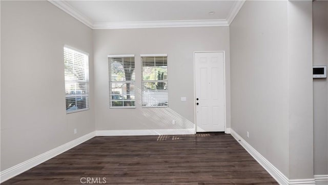 empty room with dark hardwood / wood-style flooring and crown molding