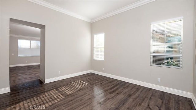 empty room with dark hardwood / wood-style flooring and crown molding