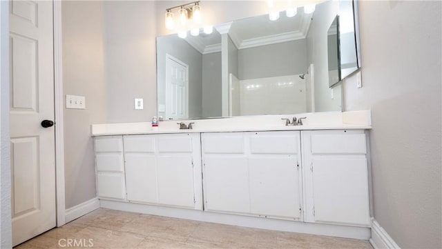 bathroom with walk in shower, vanity, and ornamental molding