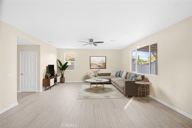 living room with light wood-type flooring and ceiling fan