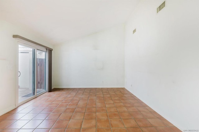 tiled empty room with a healthy amount of sunlight and vaulted ceiling