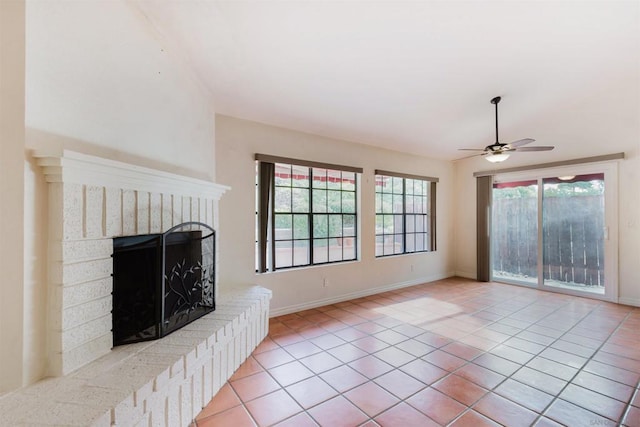 tiled living room featuring a brick fireplace and ceiling fan