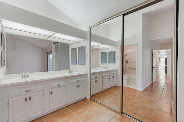 bathroom featuring vanity, vaulted ceiling, tile patterned floors, and shower / washtub combination