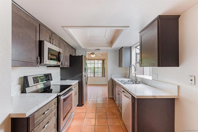 kitchen with light tile patterned floors, dark brown cabinets, sink, and stainless steel appliances