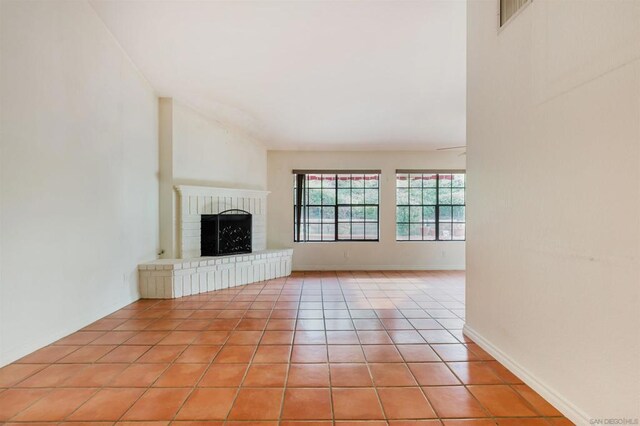 unfurnished living room featuring light tile patterned floors and a fireplace