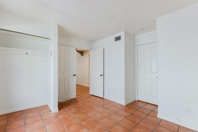 unfurnished bedroom featuring light tile patterned floors and a closet