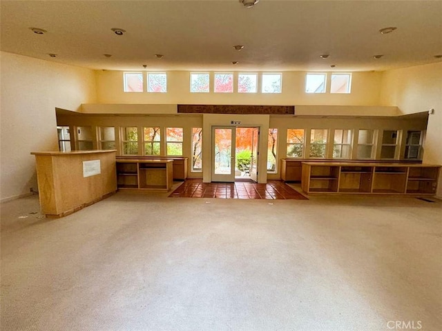 living room with a high ceiling and carpet