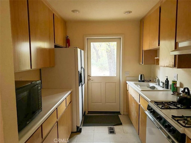 kitchen with sink, white appliances, and light tile patterned flooring