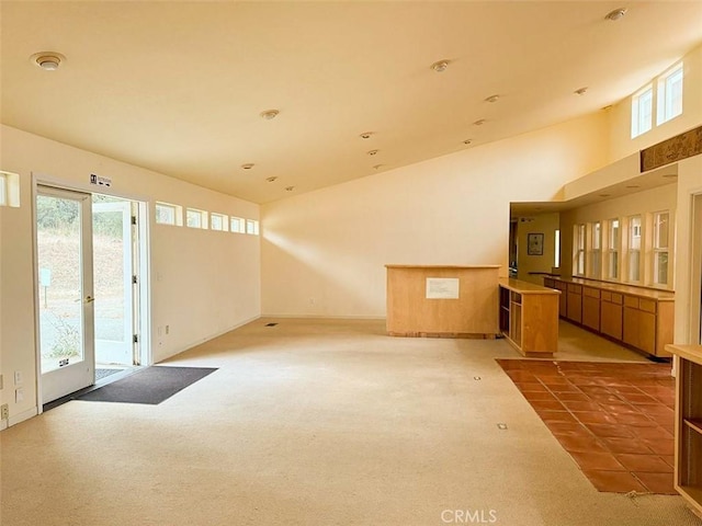 unfurnished room featuring high vaulted ceiling, french doors, and carpet flooring