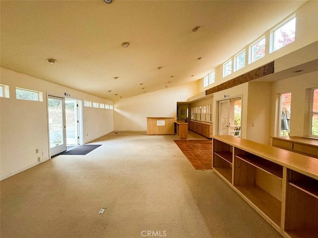 empty room with lofted ceiling, light colored carpet, and french doors