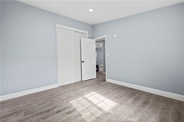 unfurnished bedroom with a closet and light wood-type flooring