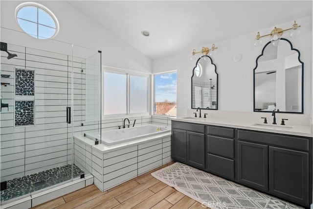 bathroom with a wealth of natural light, vanity, separate shower and tub, and vaulted ceiling