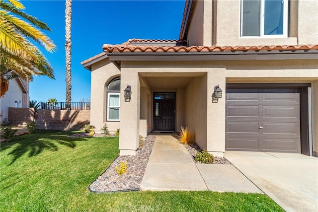 property entrance featuring a garage and a lawn