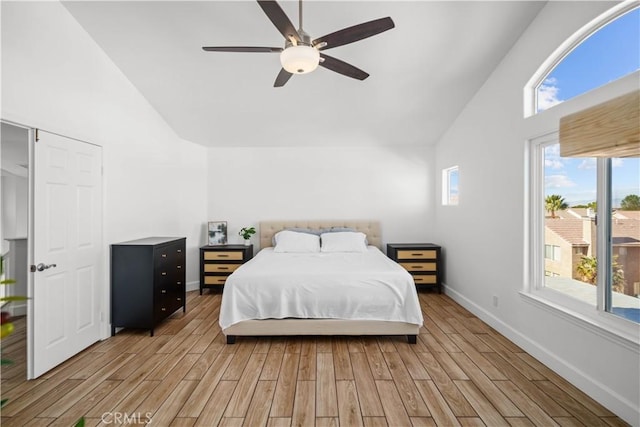 bedroom with ceiling fan, light wood-type flooring, and high vaulted ceiling