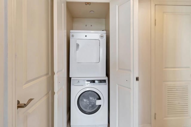 clothes washing area with laundry area and stacked washer and dryer