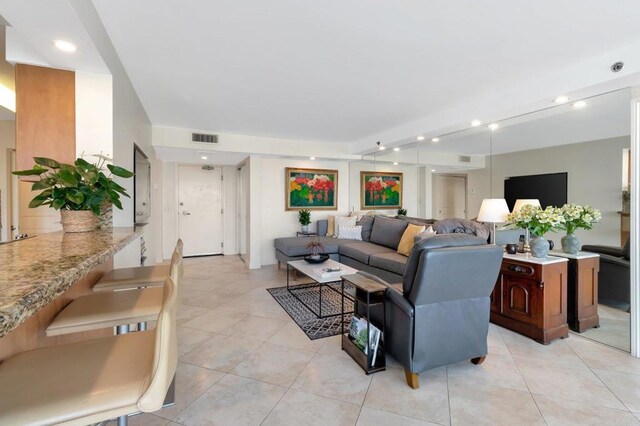living room with light tile patterned flooring, visible vents, and recessed lighting