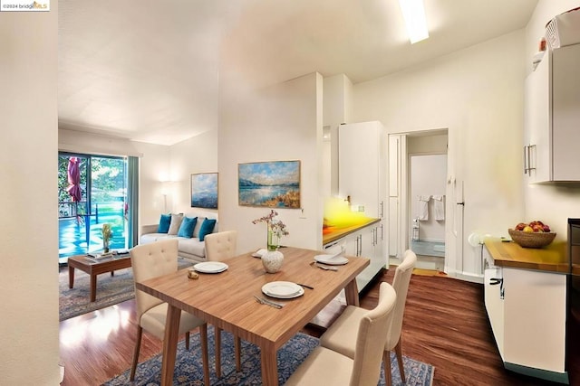 dining room featuring vaulted ceiling and dark hardwood / wood-style floors