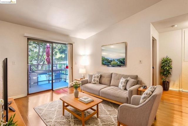 living room with light hardwood / wood-style flooring and vaulted ceiling