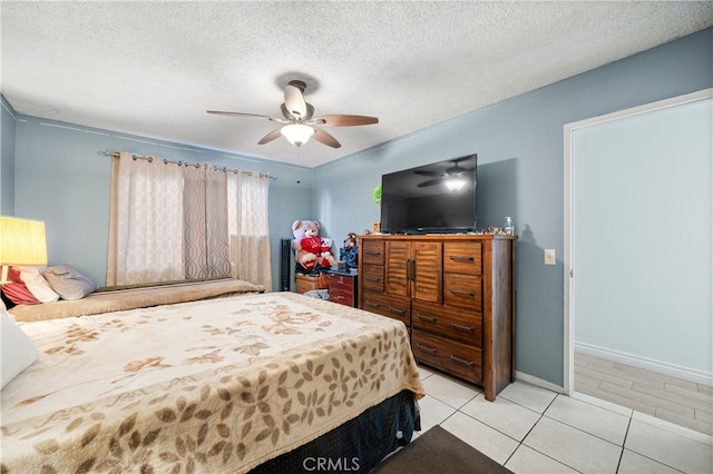 tiled bedroom with ceiling fan and a textured ceiling