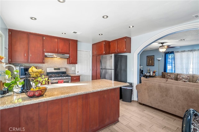 kitchen featuring kitchen peninsula, ceiling fan, stainless steel appliances, tasteful backsplash, and light hardwood / wood-style flooring