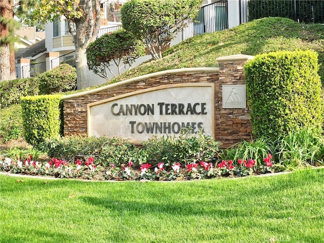 community / neighborhood sign featuring a lawn