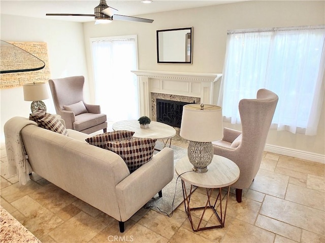 living area with ceiling fan and a high end fireplace