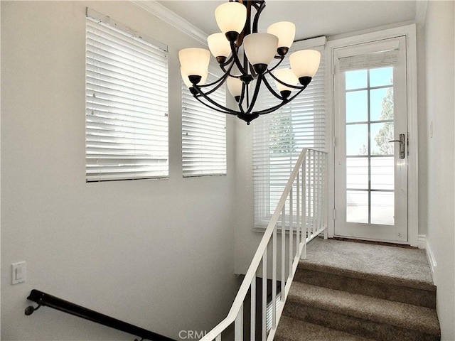 staircase with an inviting chandelier and ornamental molding