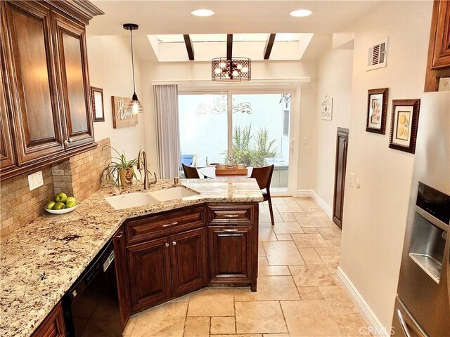 kitchen featuring decorative backsplash, sink, hanging light fixtures, light stone countertops, and stainless steel fridge with ice dispenser