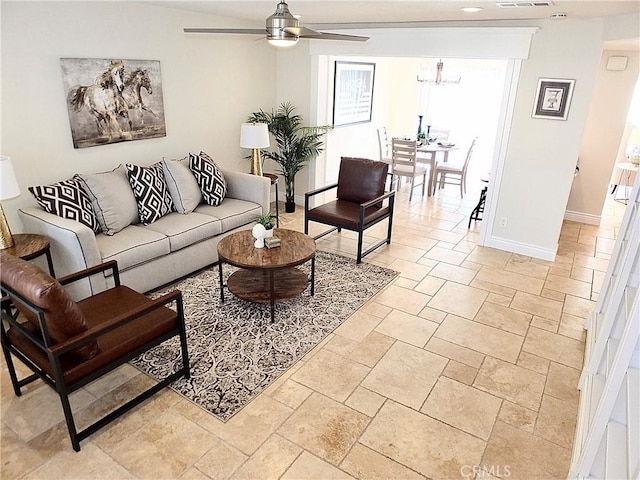 living room with ceiling fan with notable chandelier